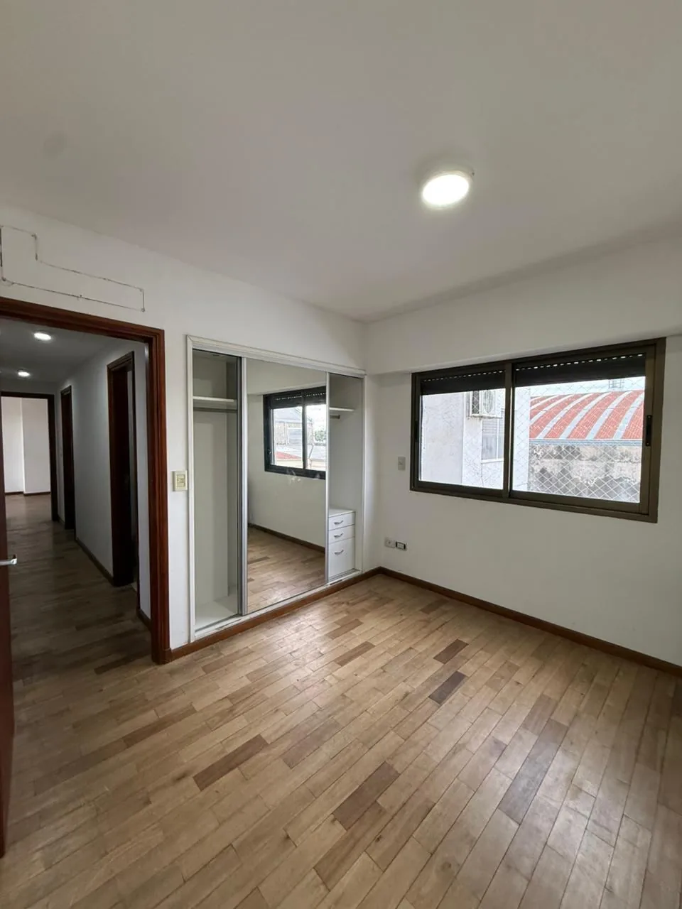 Tercer dormitorio, con ventana, placard espejado y el pasillo que conecta los dormitorios