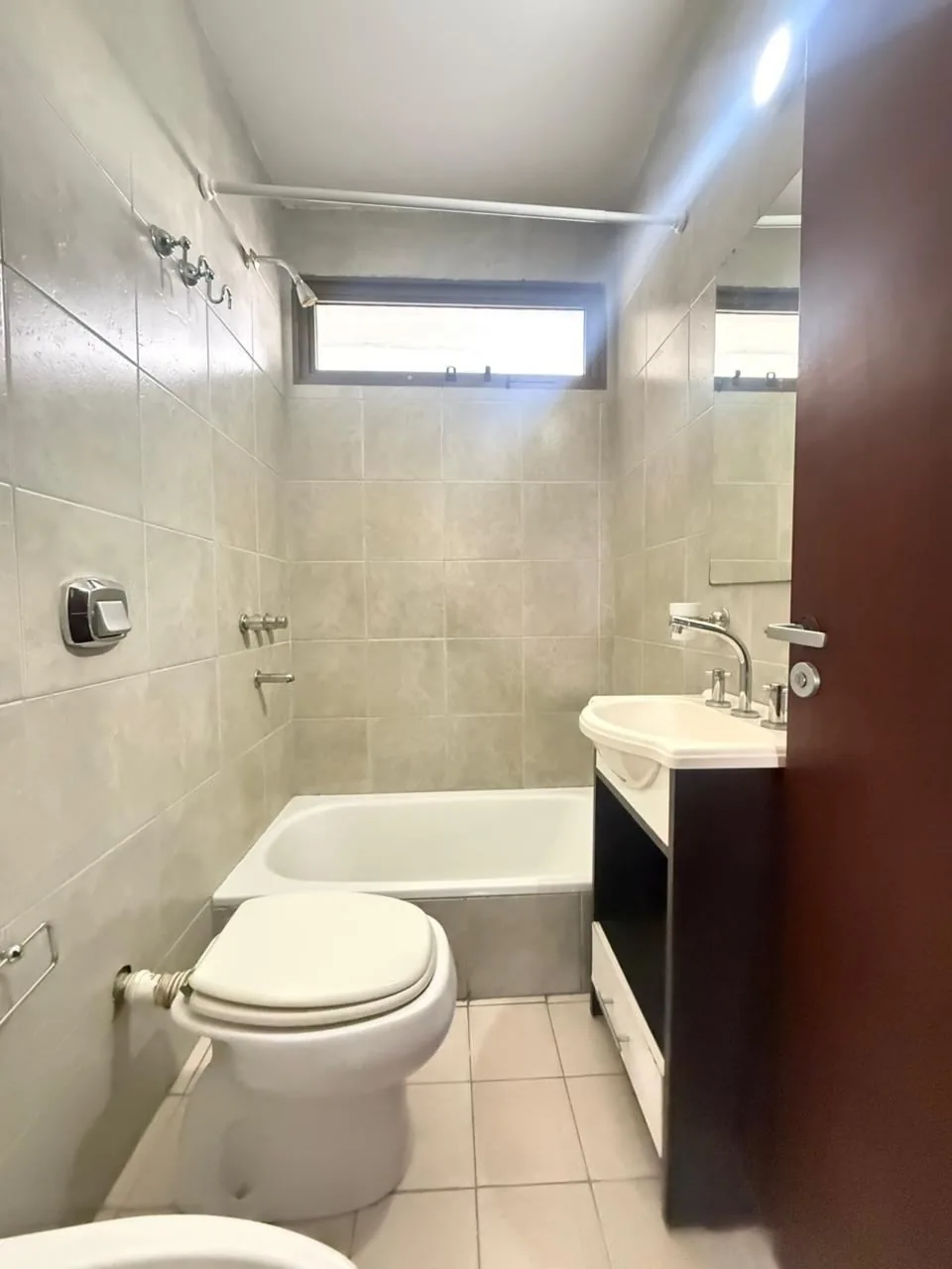 Baño completo, con bañera, ventana y vanitory con espejo